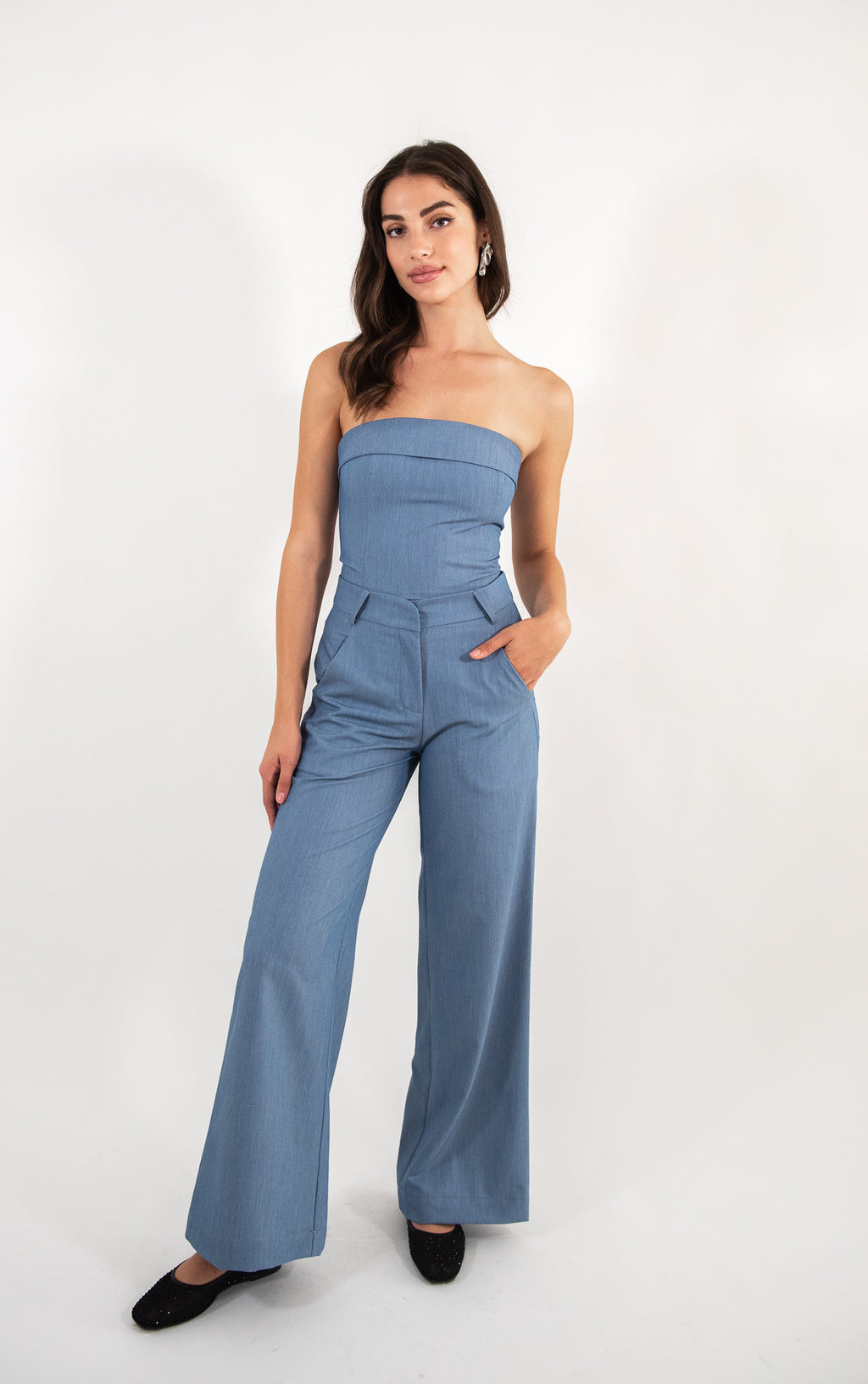 Woman wearing blue pants, full-body view.