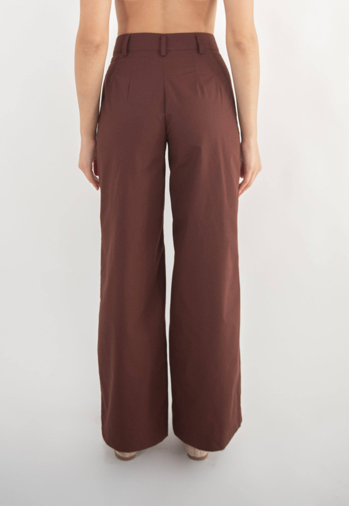 Woman wearing brown pants, back view.