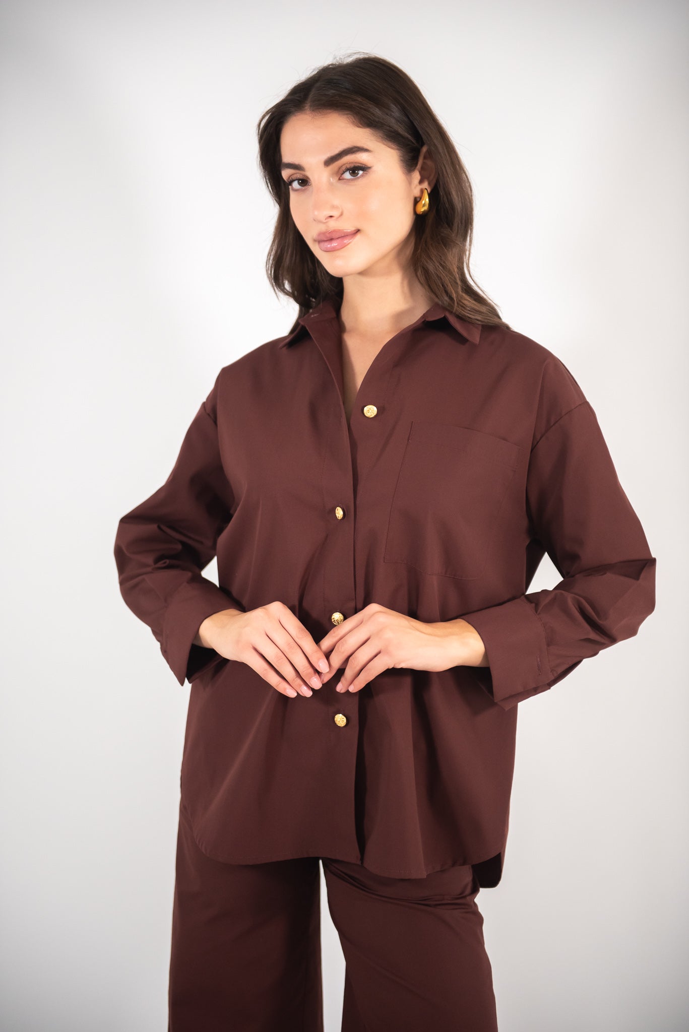 Woman wearing a brown shirt, full-body view.