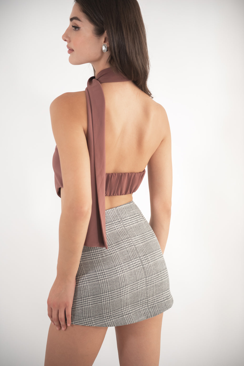 Woman wearing checkered skirt, back view