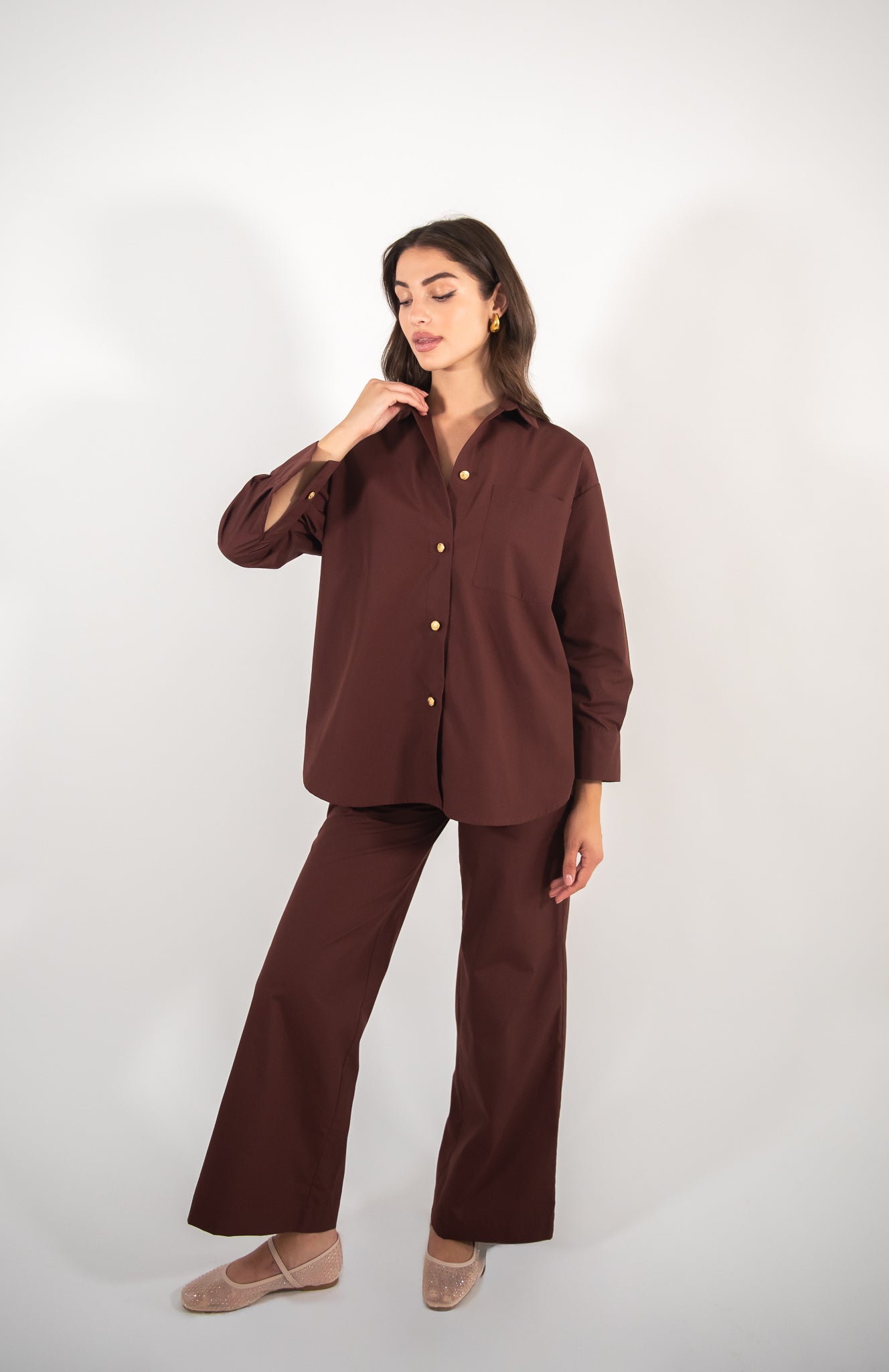 Woman wearing brown pants and brown shirt, full-body view