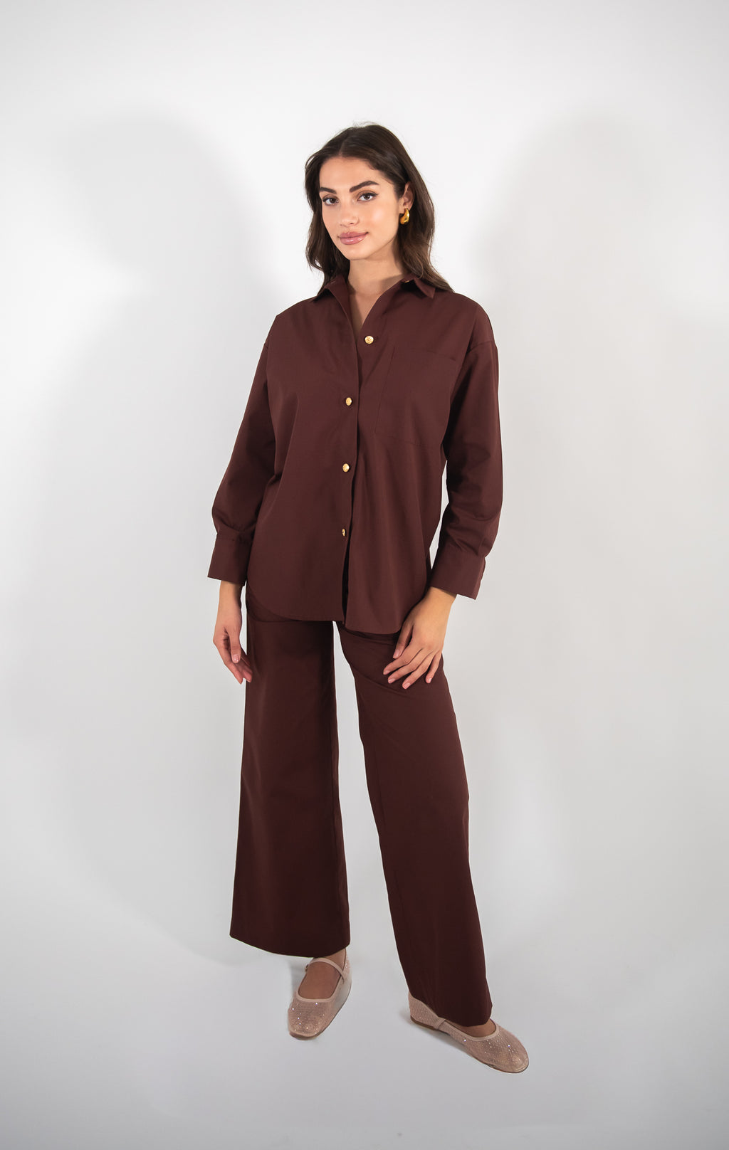 Woman wearing brown shirt, full-body view.