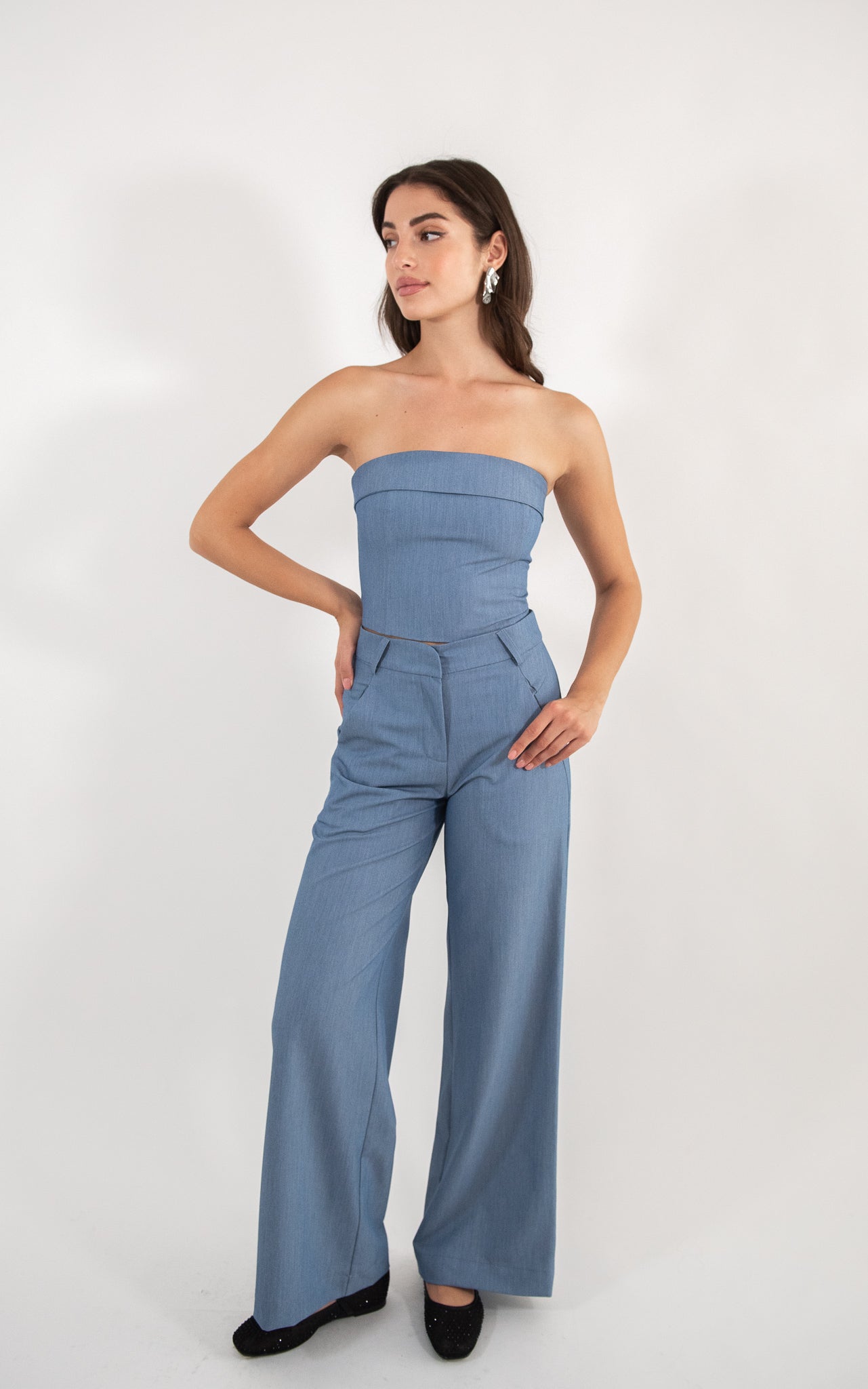 Woman wearing blue pants, full-body view.