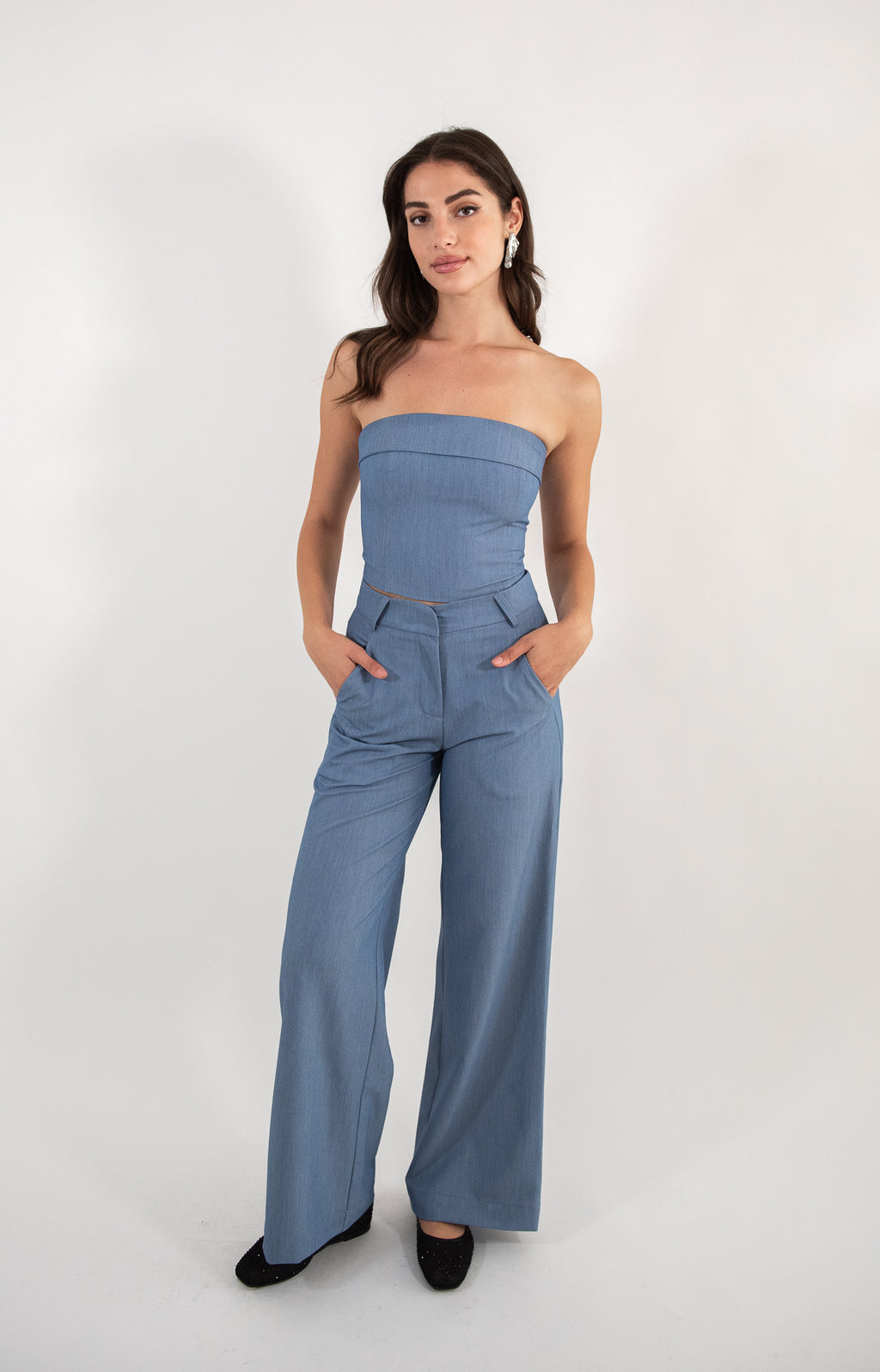 Woman wearing blue pants, full-body view.