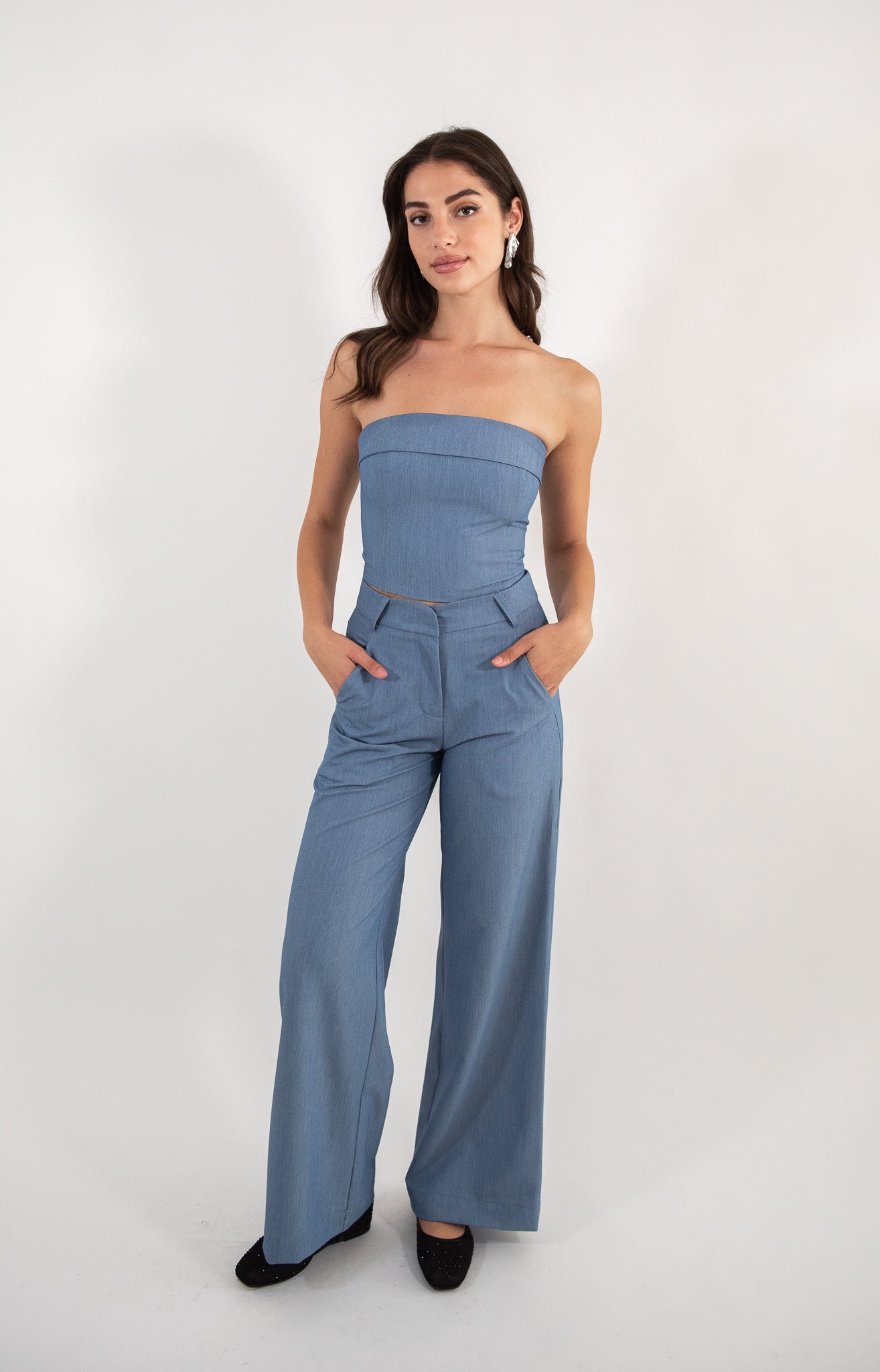 Woman wearing blue pants, full-body view.