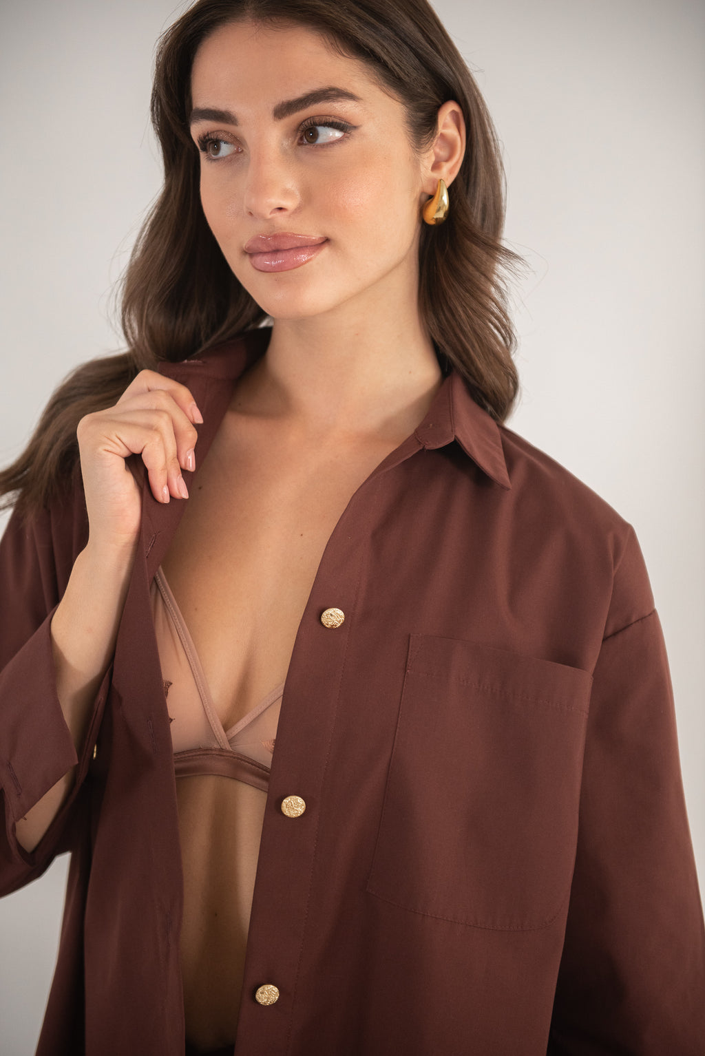 Woman wearing a brown shirt, close up view