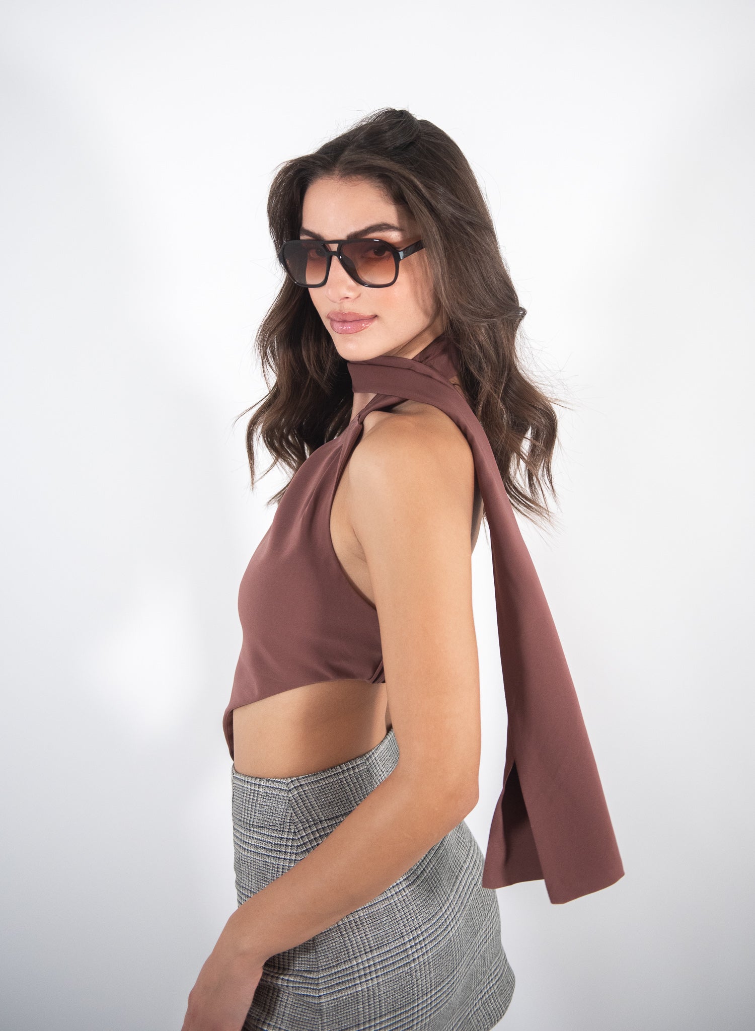 Woman wearing a brown top, side view