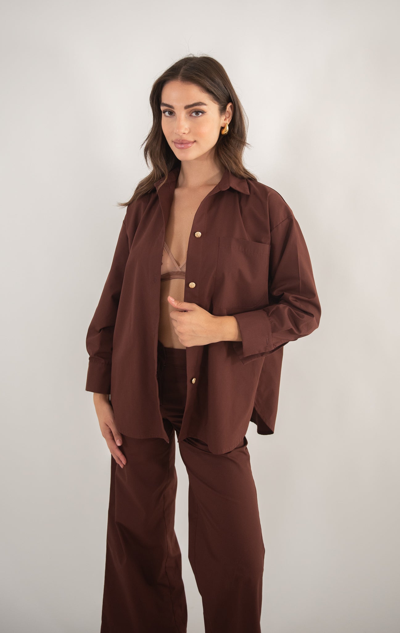 Woman wearing a brown shirt, full-body view