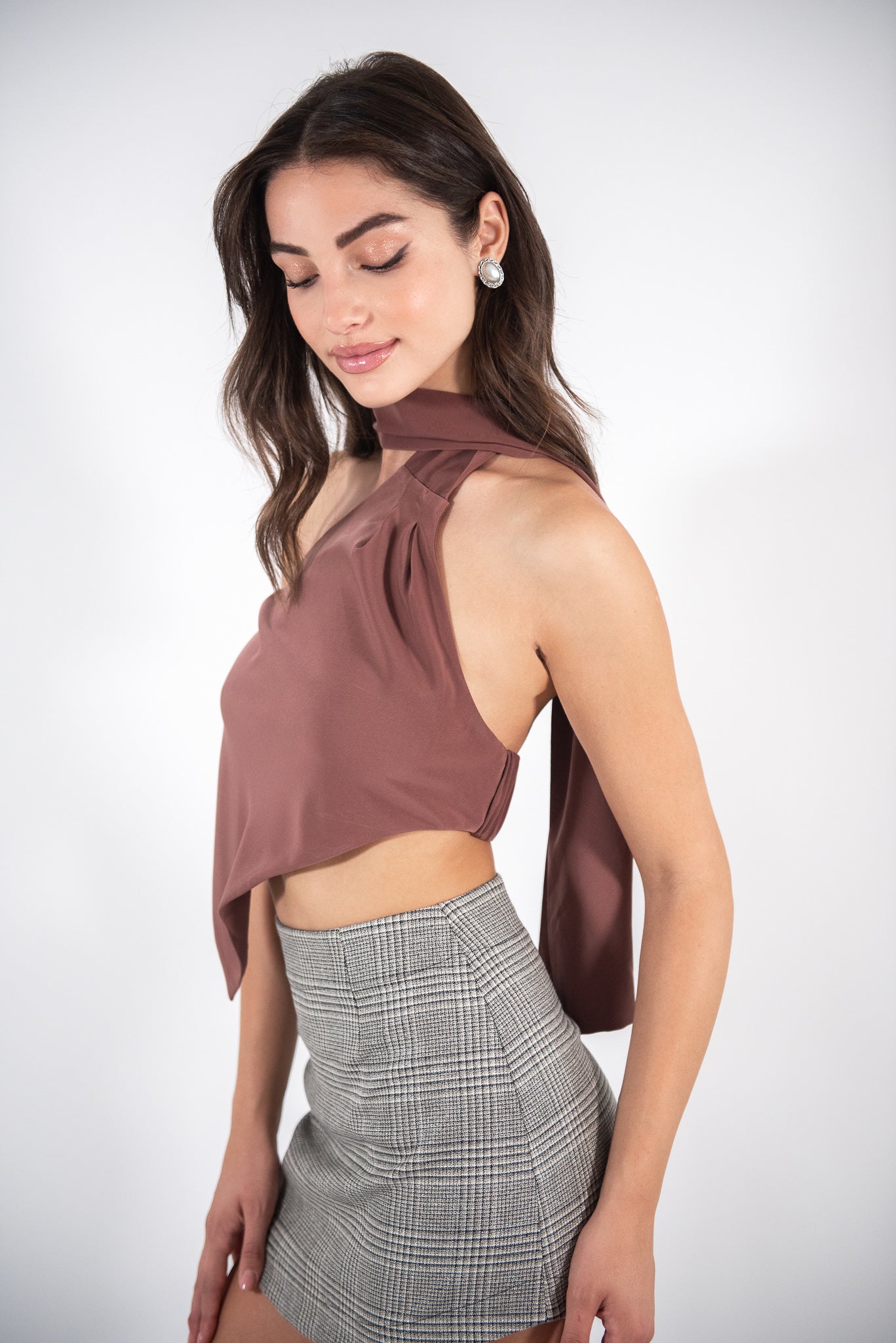 Woman wearing a brown top, side view